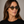 Cord Ash square sunglasses with mirror green lenses worn by female model in her 30s, close-up studio portrait styled with a black T-shirt, highlighting the ash grey eco-acetate frame and clean, modern silhouette.