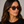 Denim Eco Havana square sunglasses with bottle green lenses worn by female model in her 30s, close-up studio portrait styled with a black T-shirt, highlighting the rich havana eco-acetate frame and clean, stru