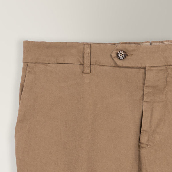 Italian-made light brown garment-dyed cotton chino with tapered leg and unfinished hem.