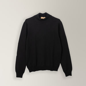 Black mock neck jumper made from 100% merino wool. Featuring a sleek mock neck and ribbed detailing on the neck, cuffs, and hem for a refined, tailored fit. 