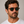 Panama Havana square sunglasses with bottle green lenses worn by male model in his 30s, close-up studio portrait styled with white cotton T-shirt.
